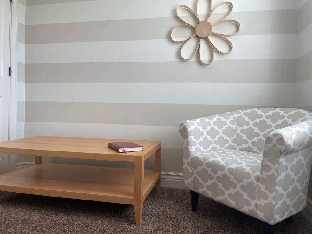 A longe table with a book on it and a sofa besides the table - Built by Fox in the Sawdust in Rexburg ID cutom table build